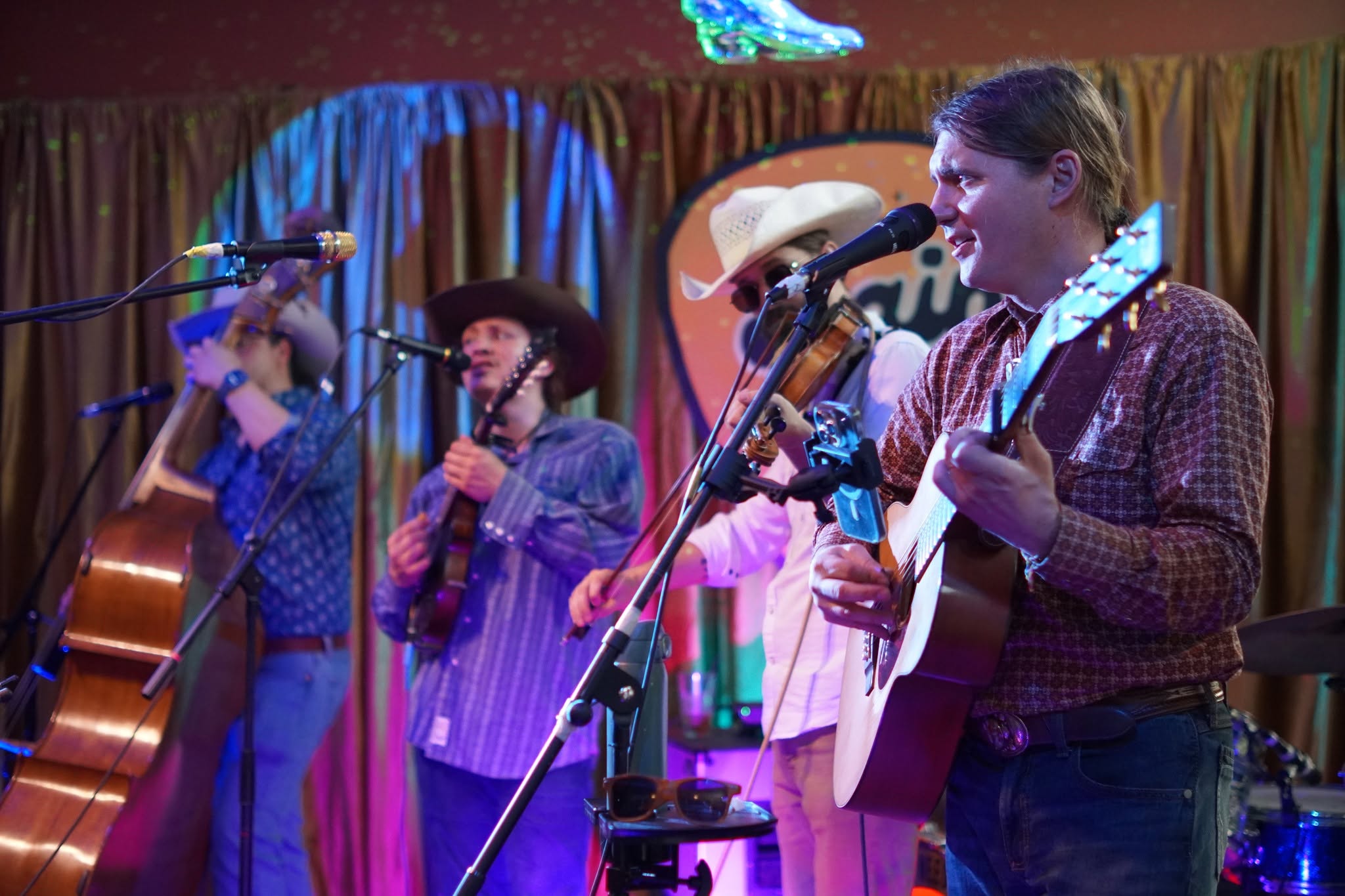 An acoustic ensemble with upright bass, mandolin, fiddle and guitar