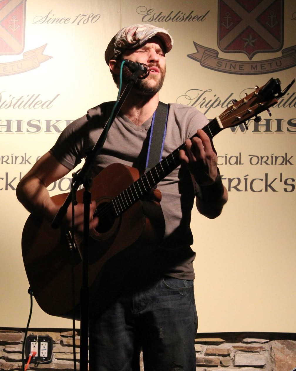 Quinn Walton singing and playing acoustic guitar at Fado Irish Pub