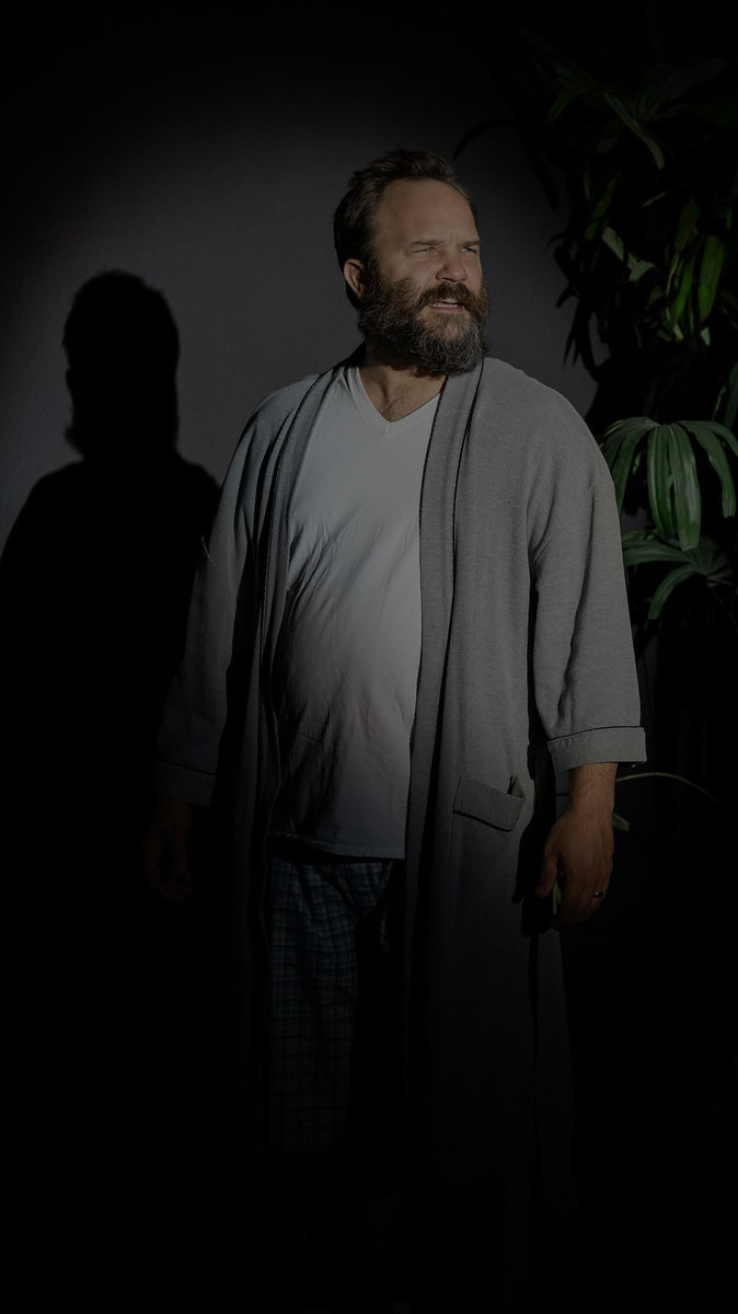Quinn Walton standing in dramatic stage light